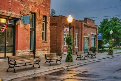 Explore the quaint streets of historic downtown Wabasha, MN with rustic benches and brick buildings.